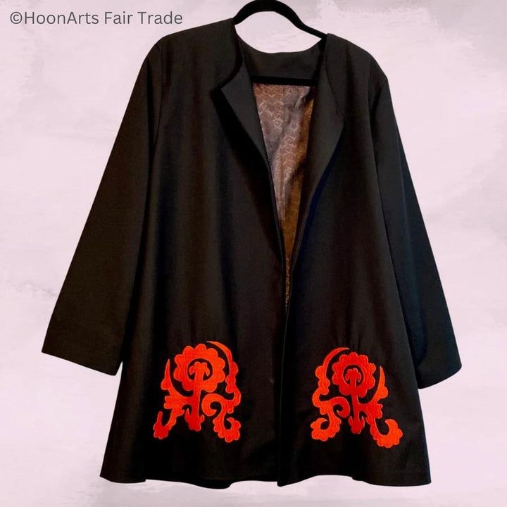 Black swing jacket on clothes hanger, showing front view and large red embroidery patterns at bottom front left and right